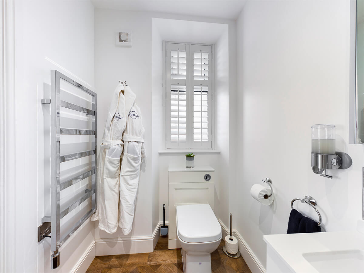 Room One - full room image showing bathroom suite, towel rail and furniture