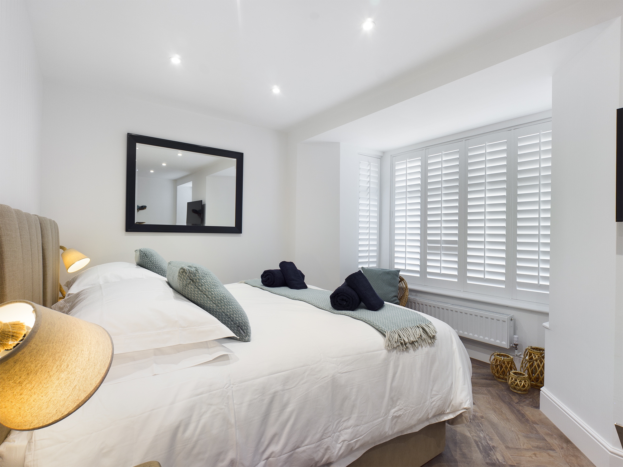 Room Three - full room image showing bed, large window, lamp and seat