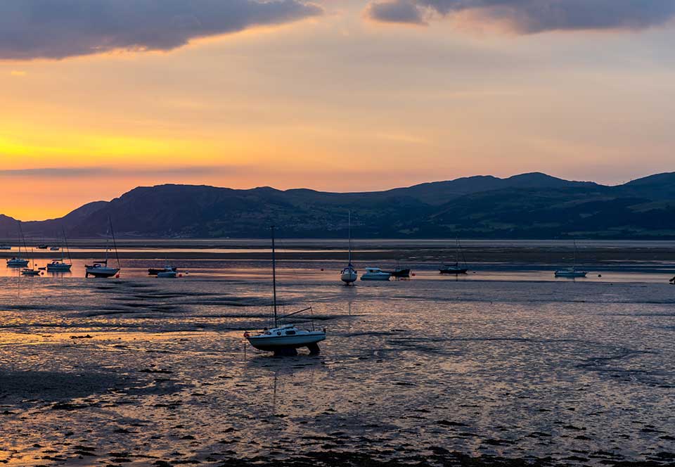 Colorful-sunrise-on-the-Menai-Strait-and-mountains-of-Snowdonia-at-low-tide