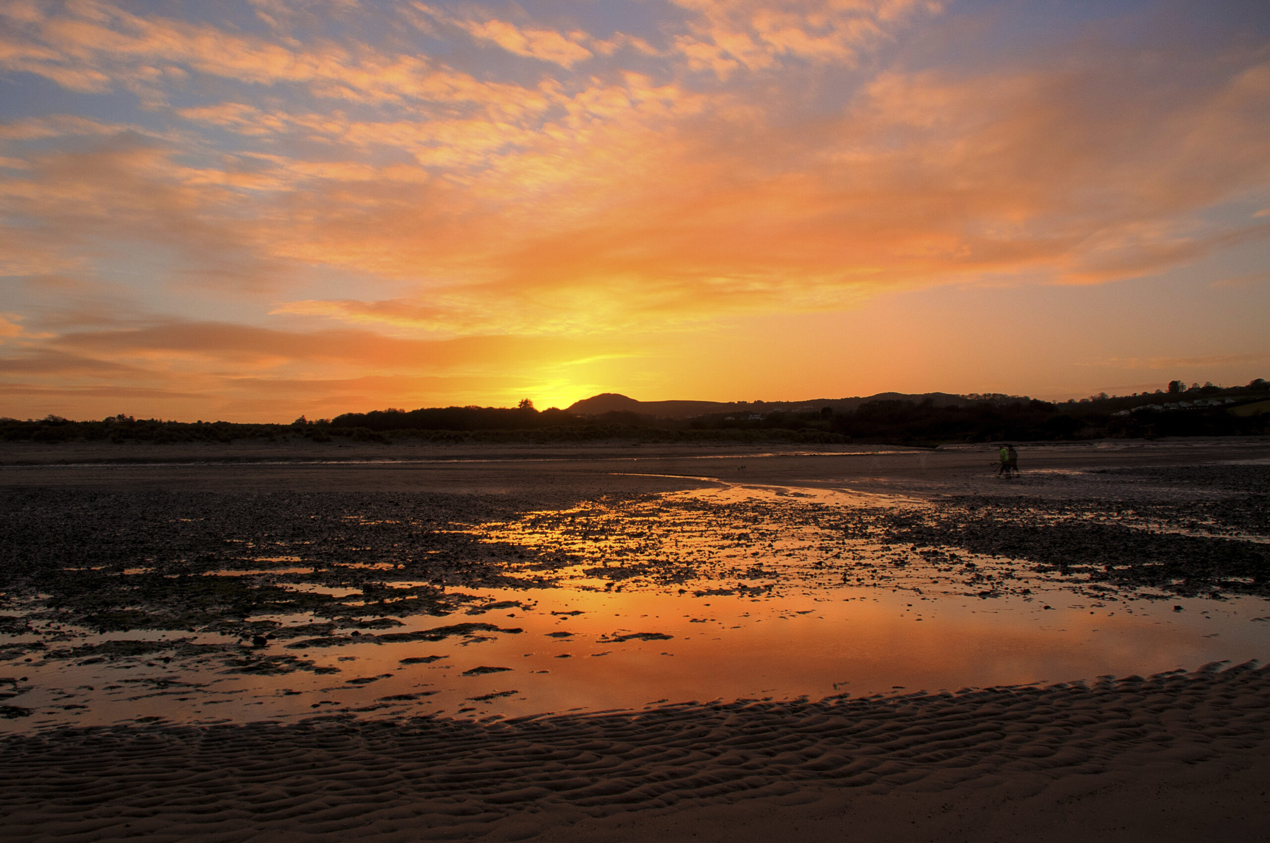 The beach at Red Wharf Bay, Anglesey, North Wales illuminated by the setting sun
