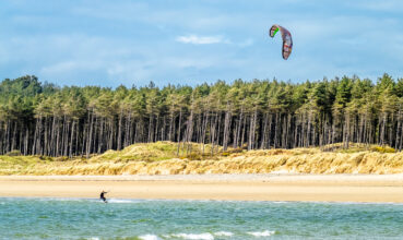 NEWBOROUGH / WALES - APRIL 26 2018 : Kite flyer surfing at Newborough beach - Wales - United Kingdom