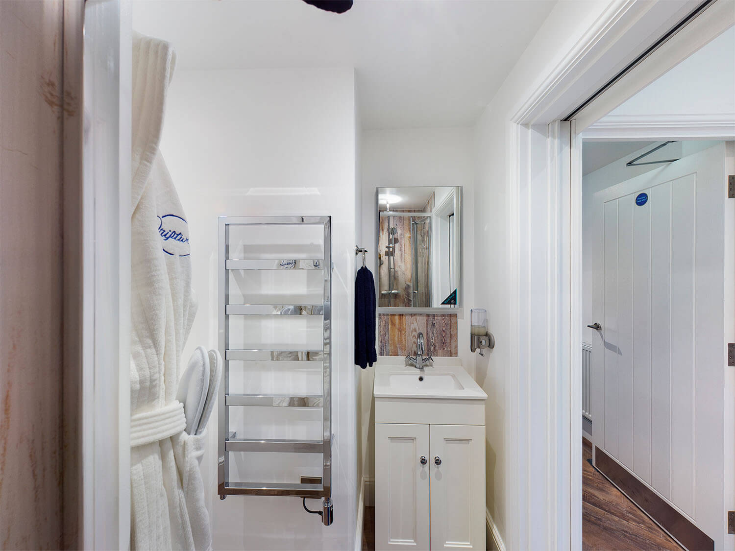 Driftwood Lodge bathroom with heated towel rail, bathrobe, sink and towels