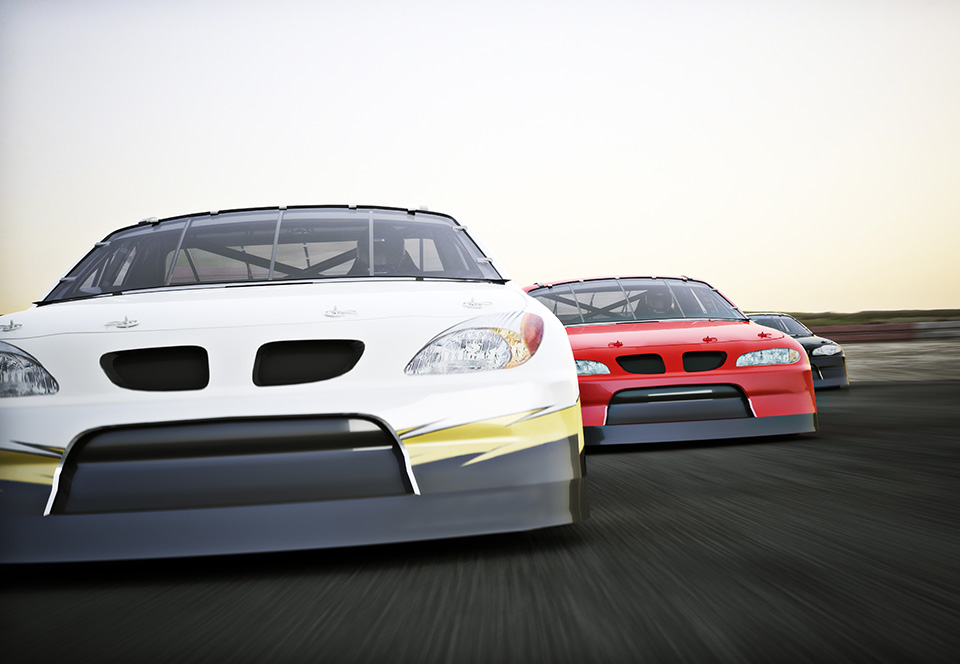 Front view of auto racing race cars racing on a track