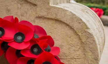 Red-poppy-wreaths-laid-at-the-bottom-of-a-war-memorial-for-Remembrance-day