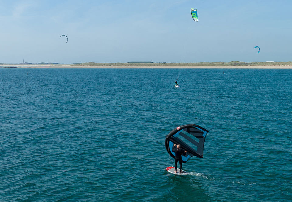 image of a windsurfer on the blue waters near Rhosneigr